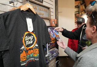 People look at eclipse merchandise for sale in the park headquarters gift store on October 13, 2023 in Capitol Reef National Park, Utah. An Annular Solar Eclipse will pass over Torrey and Capitol Reef National Park on the morning of October 14th.