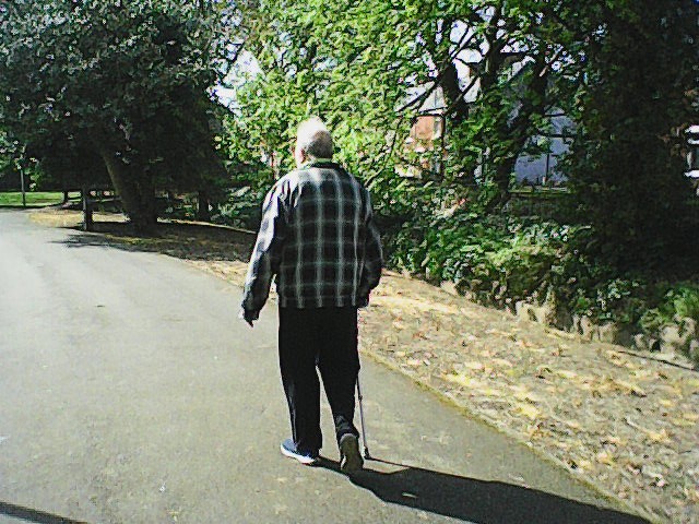 Low res photo taken on dumbphone of man with walking stick