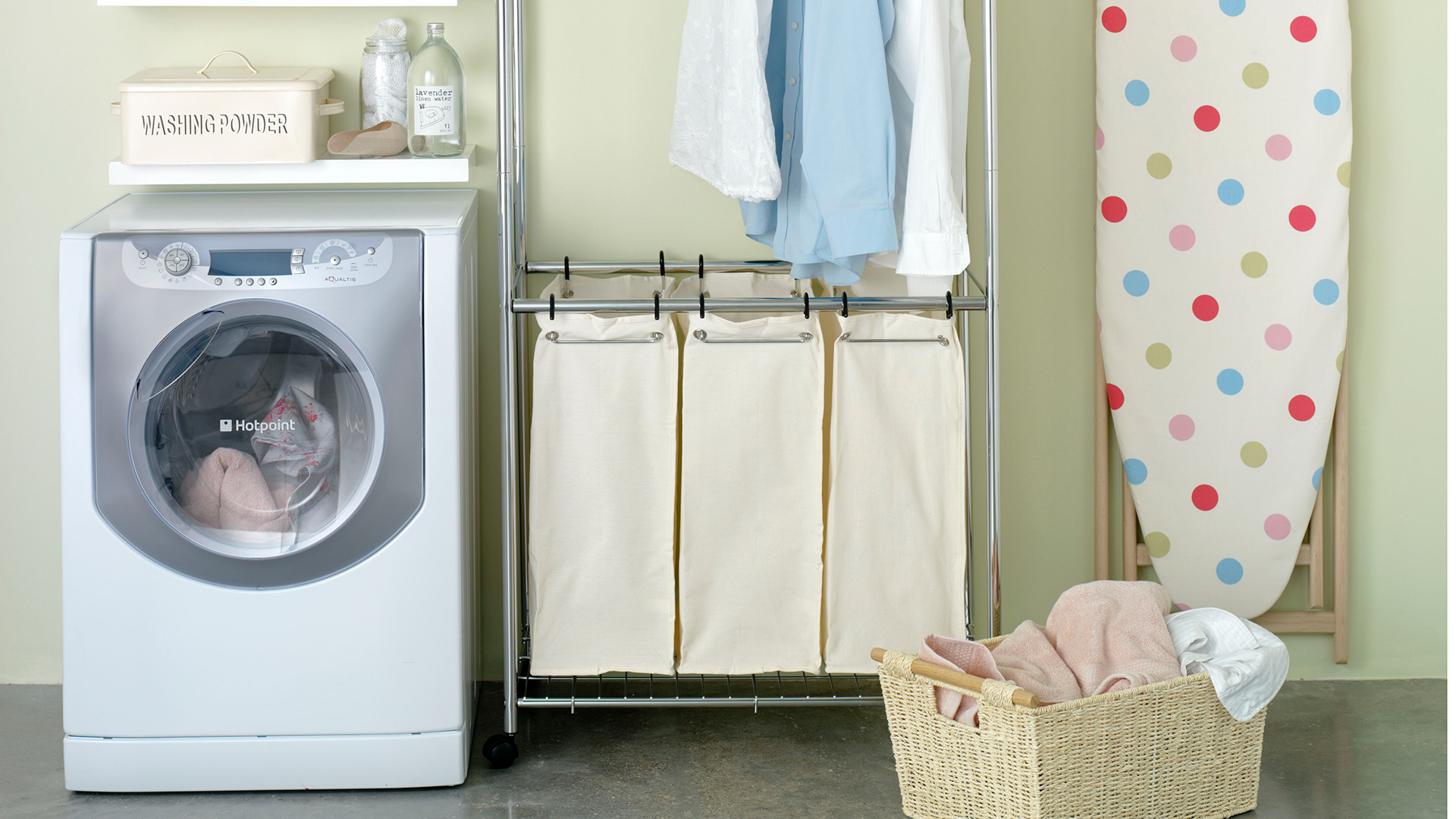 Laundry room with washing machine laundry baskets and ironing board