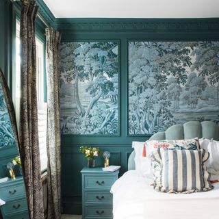 a bedroom with wall panelling and wallpaper inserts, a green colour drenched space and heavy patterned curtains