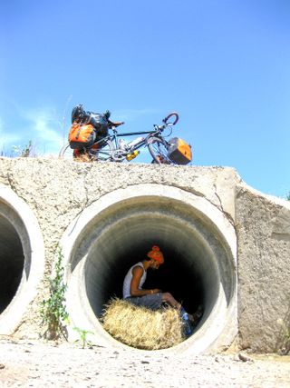 Julian Sayarer hides in a tunnel with his bike on a bridge on top