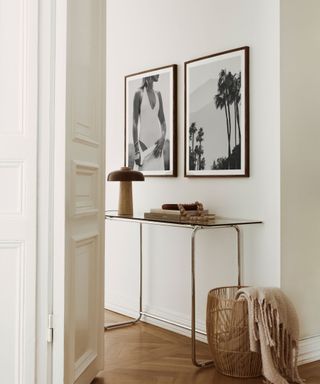 A white entryway with wall art and a console table