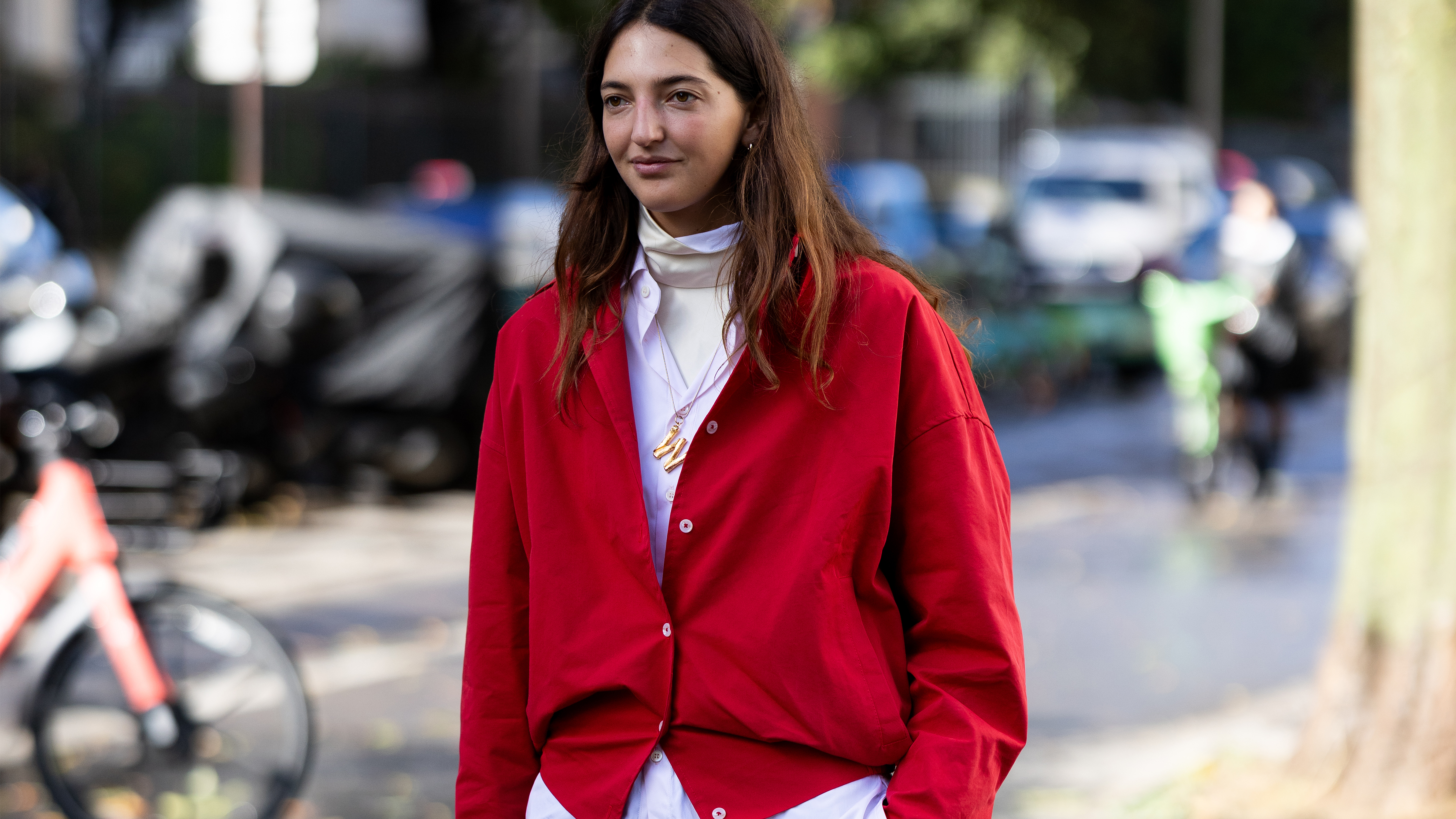 Marta Oldrini wears a red cardigan with grey trousers at Paris Fashion Week 2025.