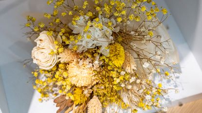 A bunch of dried flowers with yellow mimosa on table