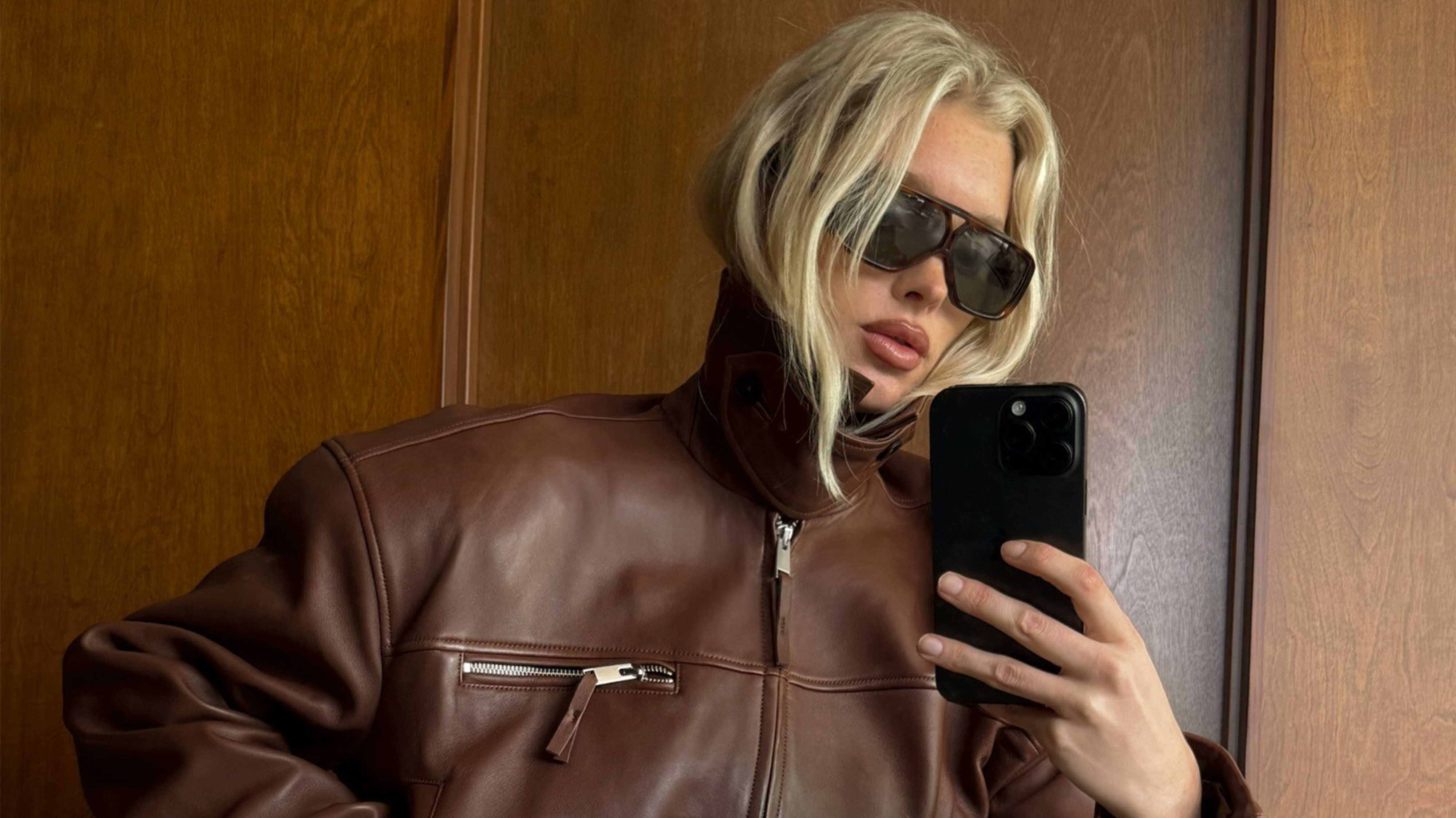 Elsa wears a brown leather jacket. 