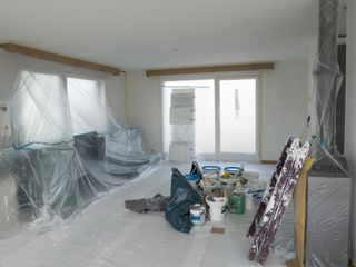 Dust sheets covering room when painting a ceiling