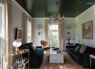 living room with dark green ceiling and velvet sofas