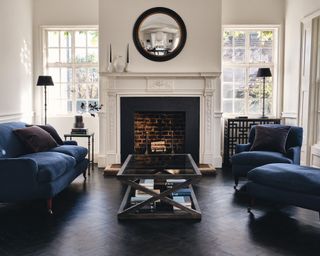 A mirror idea in a UK townhouse with a black framed mirror and blue velvet sofa furniture