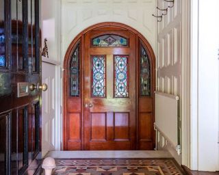 wooden front door and stained glass window