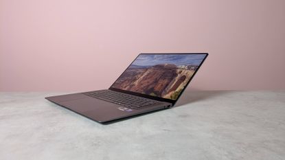 Three-quarter view of Samsung Galaxy Book6 Pro open on white desk with pink wall in background