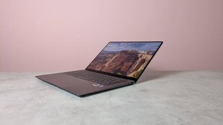 Three-quarter view of Samsung Galaxy Book6 Pro open on white desk with pink wall in background