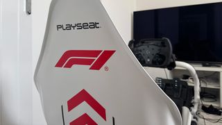 A Playseat Formula Instinct F1 Edition review image of the back of the chair pointing at a TV