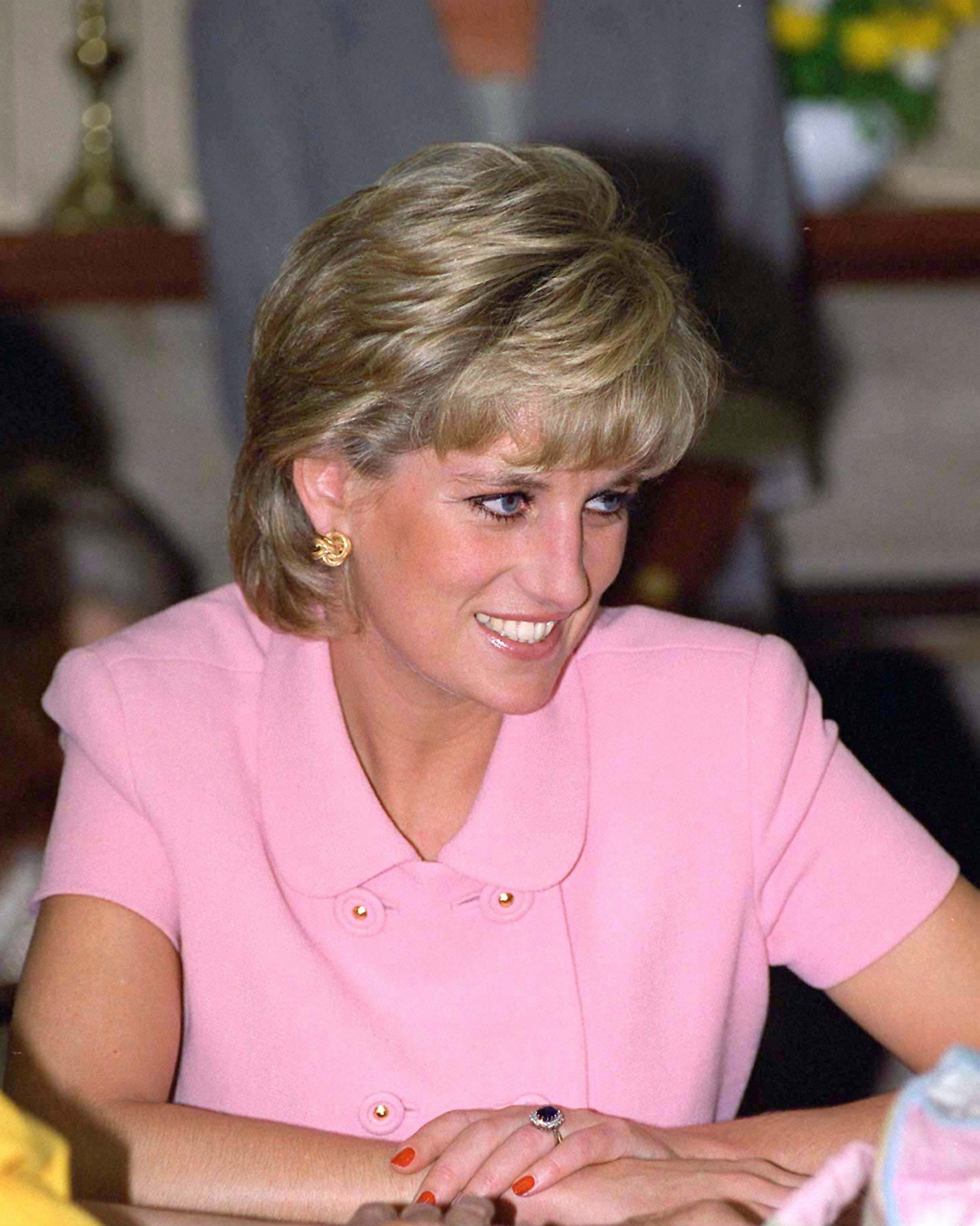 Princess Diana wearing a pink suit and smiling