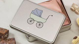 Silver tin with a baby pram on the front with brownies inside as part of our best baby shower gifts roundup