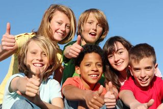 happy european kids making thumbs up sign