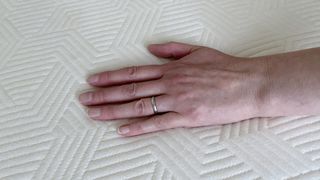 Reviewer's hand resting on cover of Panda Hybrid Bamboo Mattress