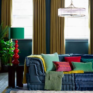 best colour combinations, navy and flax living room with navy walls and sofa, flax coloured curtains, bright cushions on sofa, red table lamp