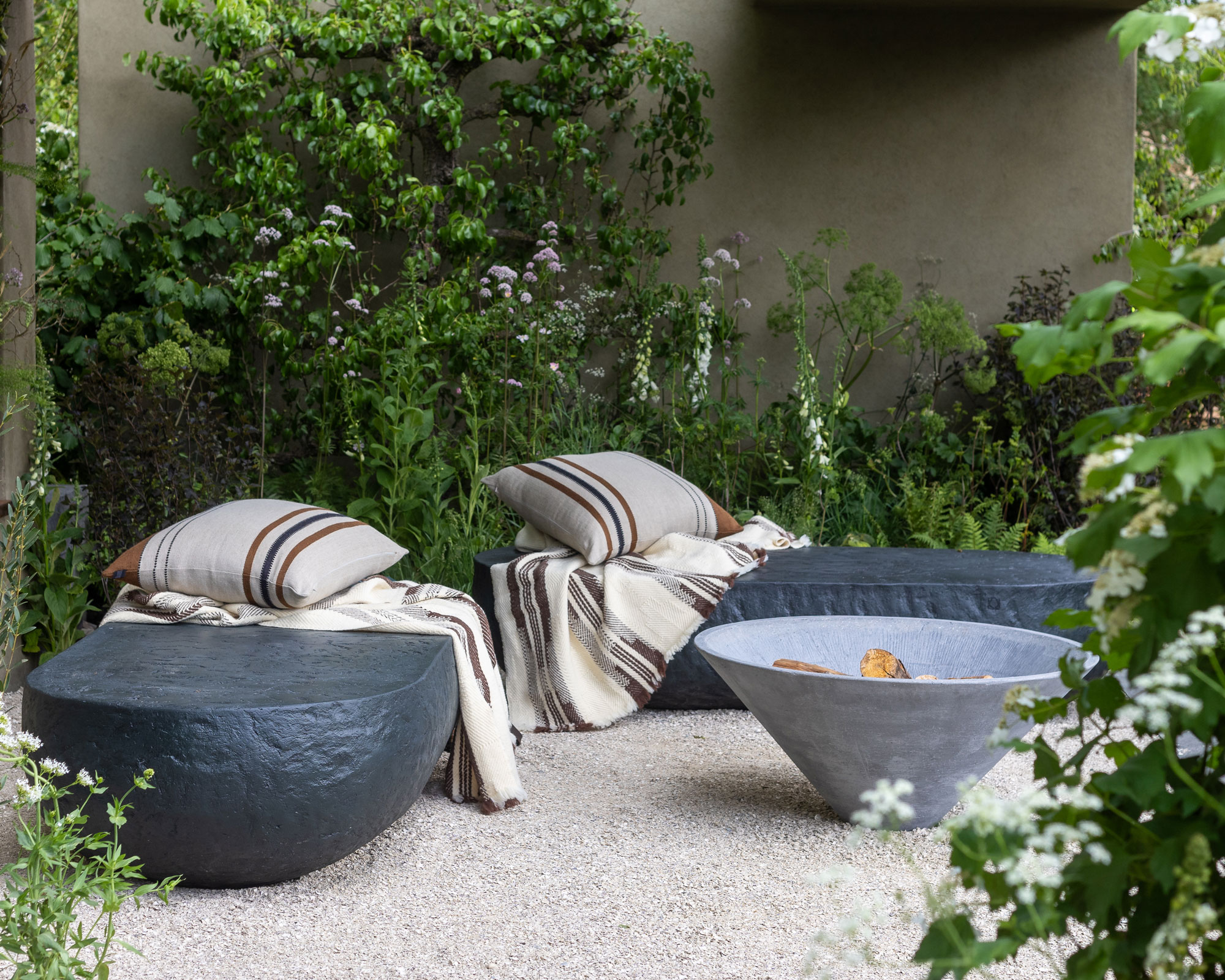 firepit with outdoor seats, painted wall and climbing plants, with gravel landscaping