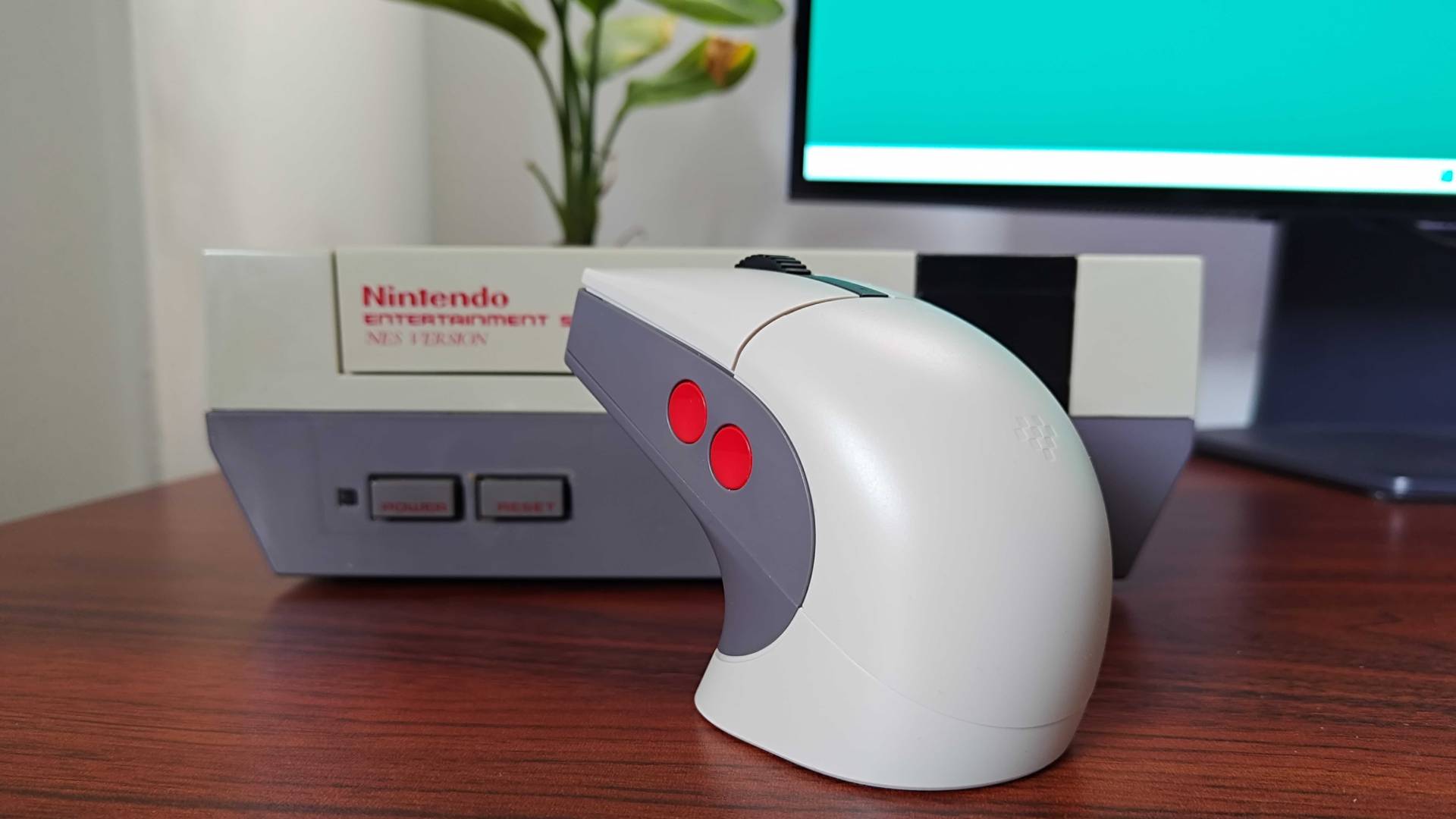8Bitdo Retro R8 mouse on woodgrain desk with NES console in backdrop
