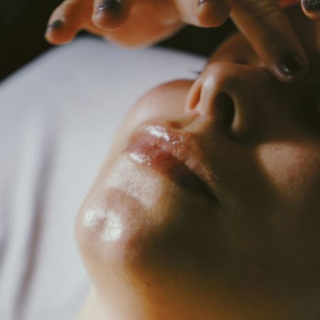 woman lying down getting a facial massage