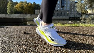 Woman's feet wearing Nike Infinity Run Flyknit 4 road running shoes - side view
