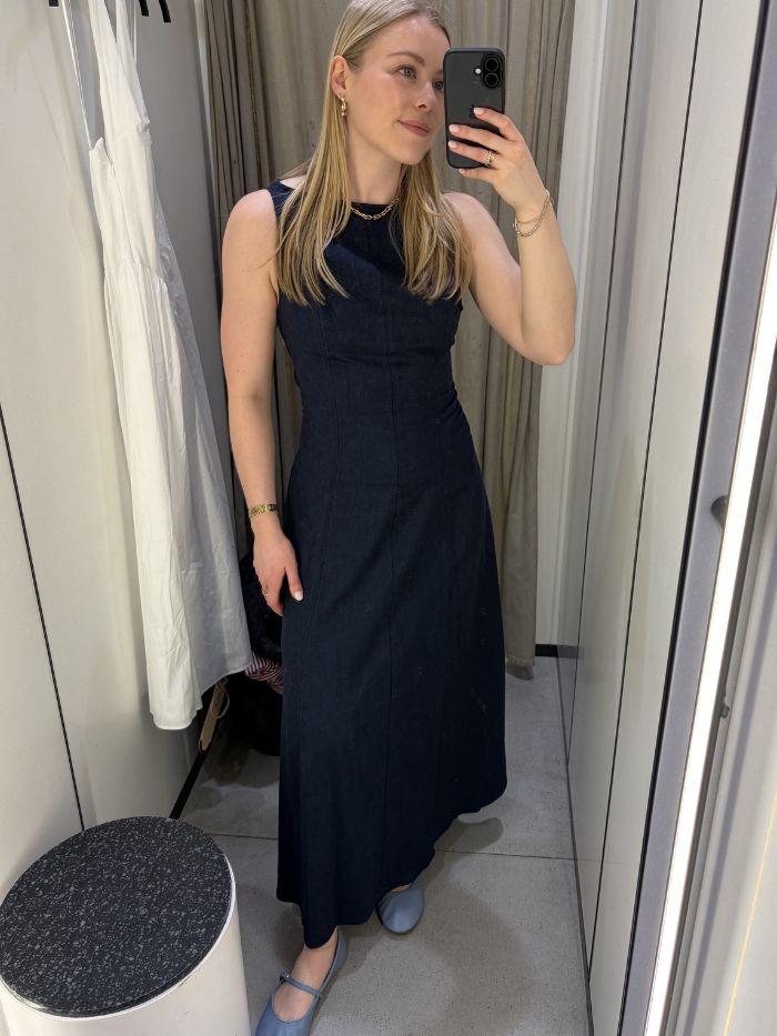 Woman wears navy fitted dress, blue ballet flats