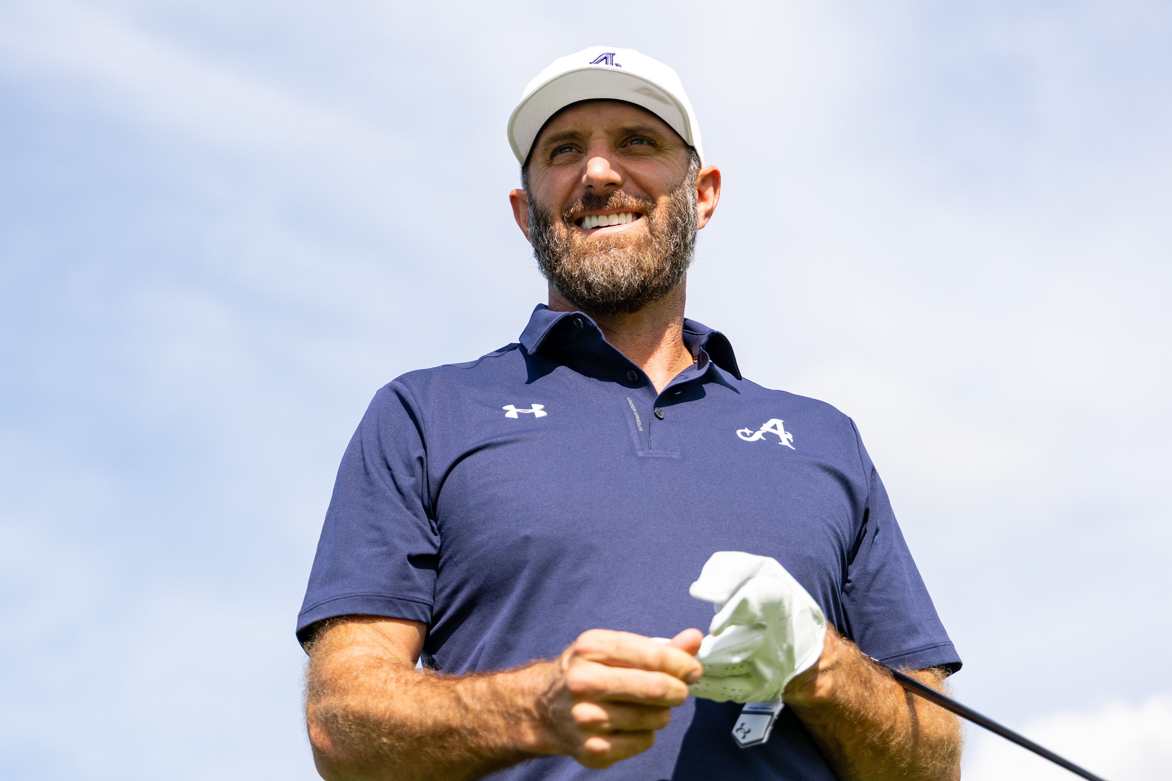 Dustin Johnson smiles while wearing Under Armour apparel