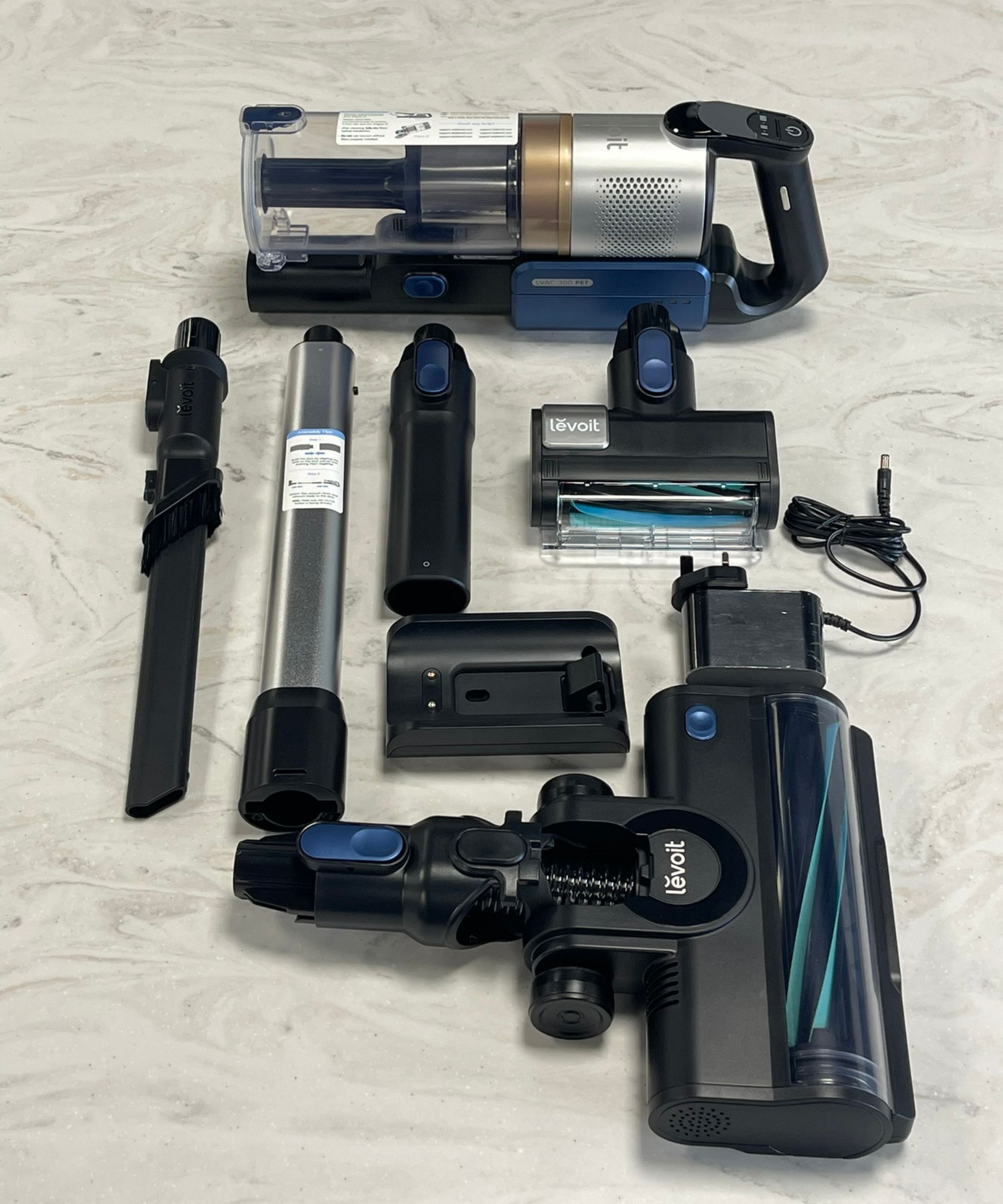 Levoit LVAC-300 cordless vacuum cleaner and all parts and attachments laid out on marble surface in Future test center.