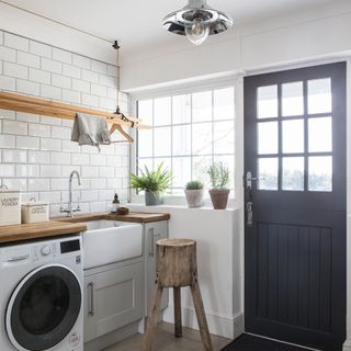 White utility room with laundry rail above belfast sink