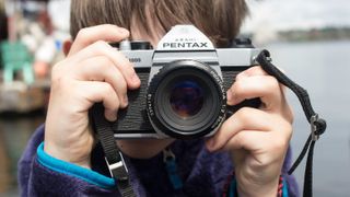 Boy using Pentax K1000 film camera