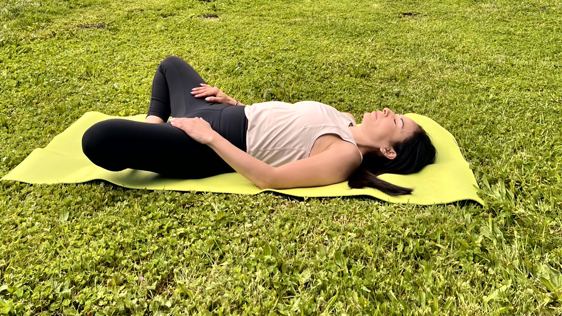 Woman in yoga pose on a mat in her garden