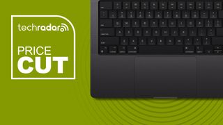 Space Black MacBook keyboard against a green TechRadar deals background