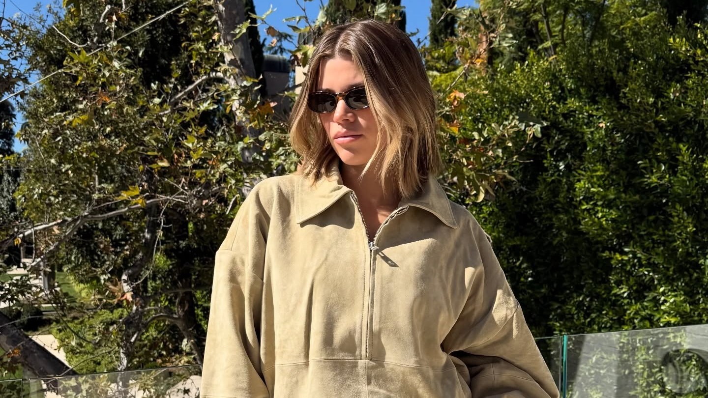 Sofia Richie Grainge wears an SRG Atelier suede bomber jacket, jeans and tan slingback heels. 