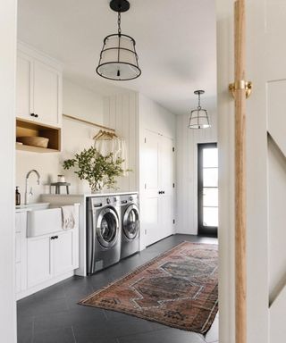 A mudroom laundry area with two washing machines and an ethnic-inspired patterned rug