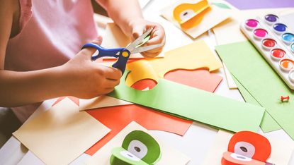 Child cutting out paper shapes