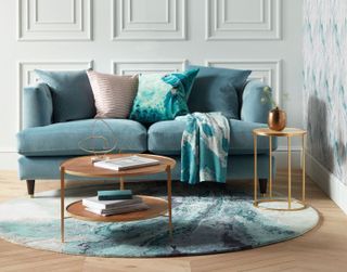 John Lewis & Partners Chester sofa in a white living space with wall panelling, a wooden floor, bronze side tables and a white and blue rug