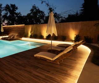 Rope lights around a deck next to a pool