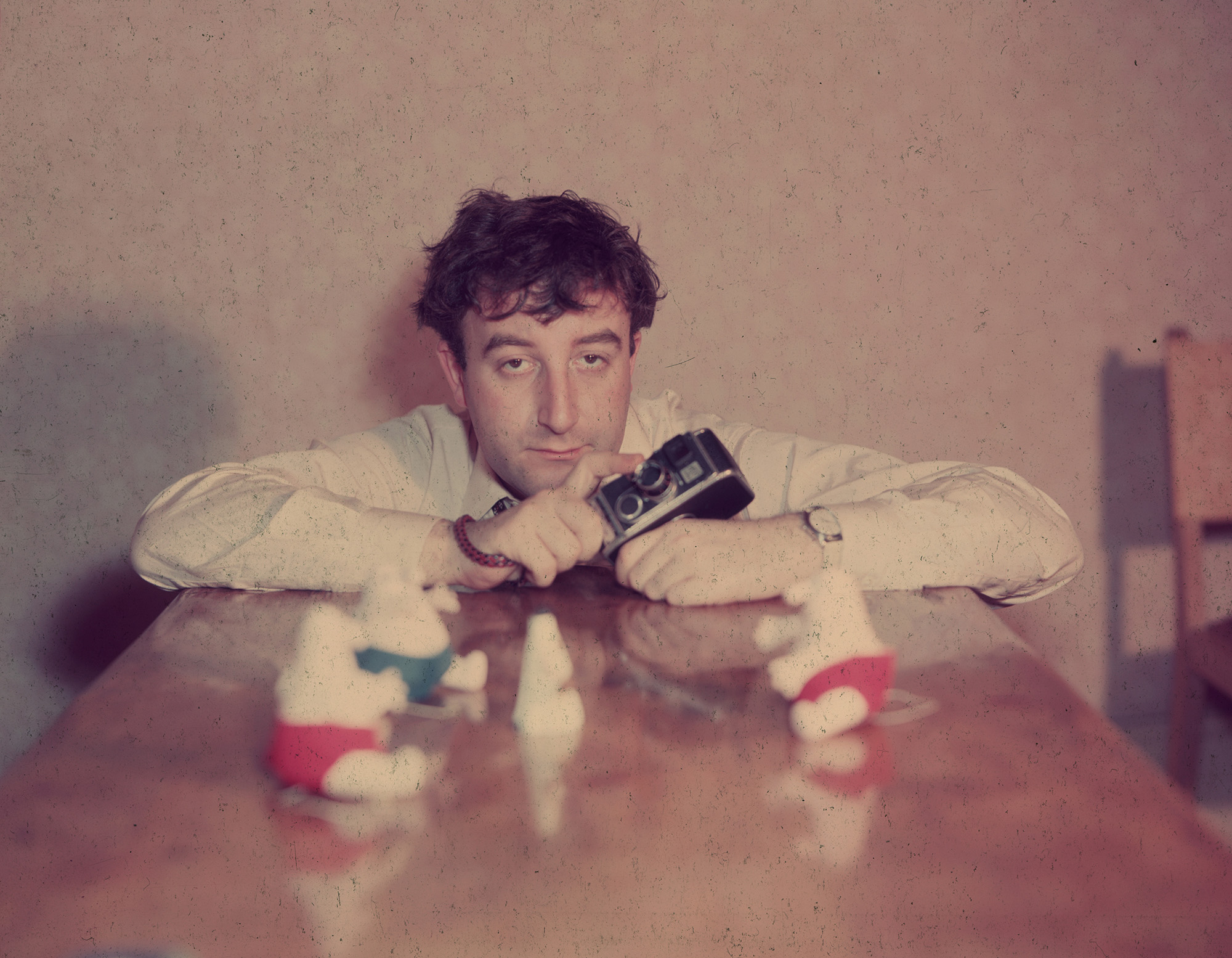 circa 1960: Comic actor Peter Sellers (1925 - 1980) holding a camera and with soft toys arranged on a table top on which he is leaning. (Photo by Hulton Archive/Getty Images)