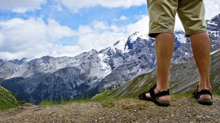 Man on mountain trail wearing sandals