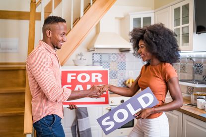 Couple with for sale and sale signs