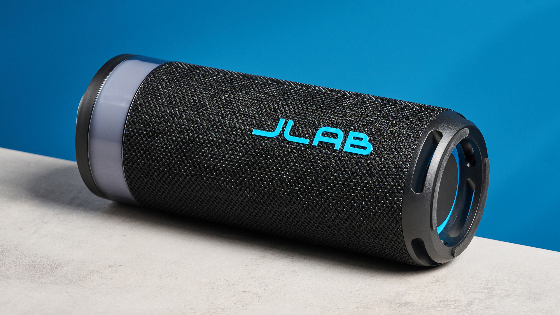 the jlab go party speaker in black with an LED RGB panel and jlab logo photographed in front of a blue background