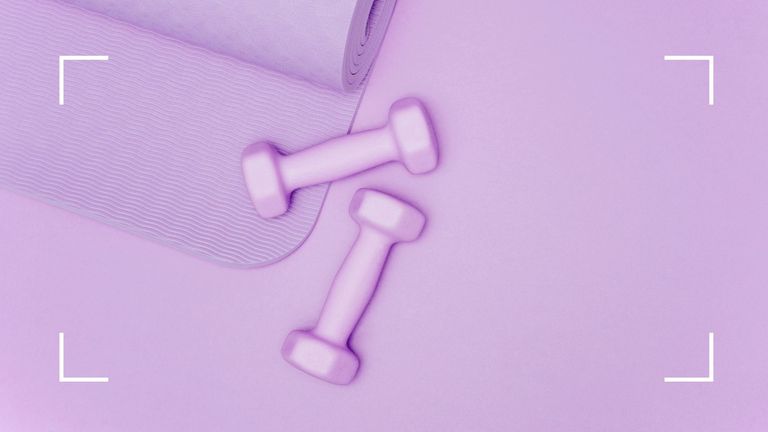 purple dumbbells and yoga mat on purple background