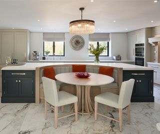 curved kitchen island with built in seating and table to one side