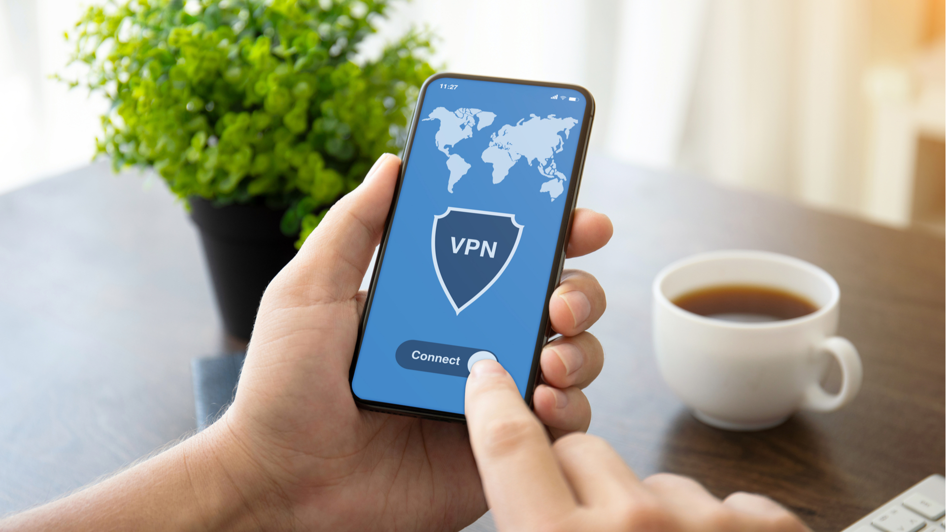 Main tenant un smartphone avec logo VPN sur l'écran