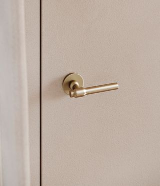 Brass door handle on cream coloured door