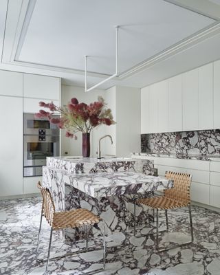 A kitchen with granite on the floor, counter and backsplash