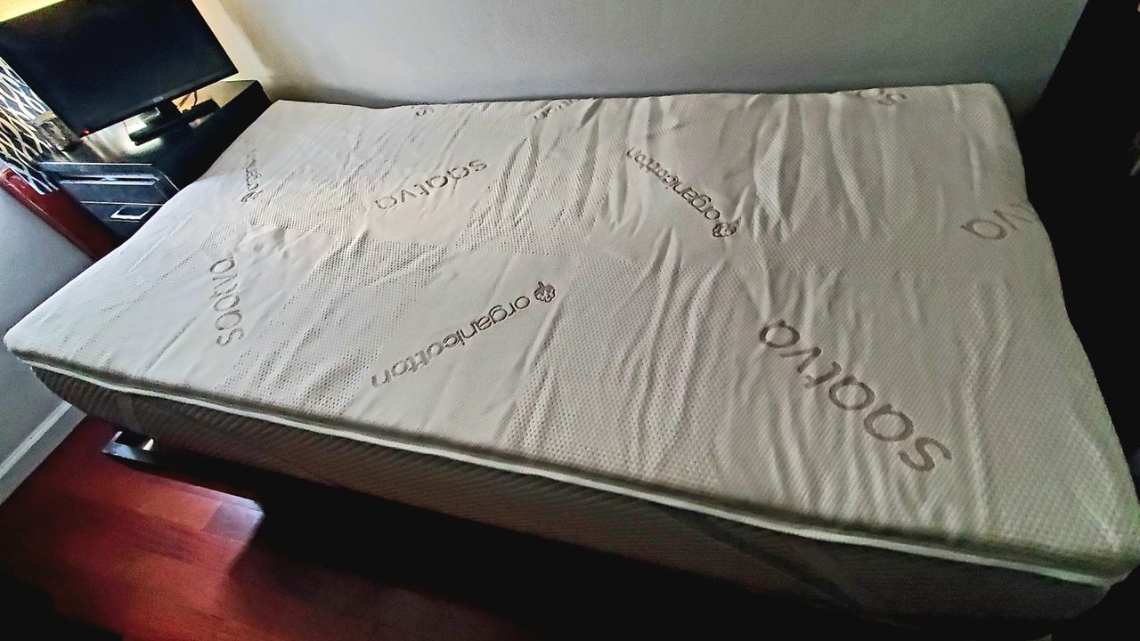 The Saatva High Density Foam Mattress Topper fully expanded on top of a twin bed