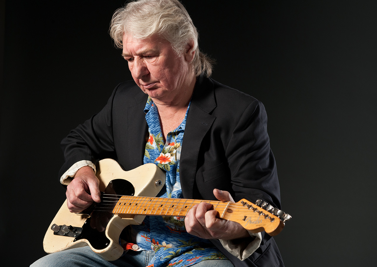 Mick Ralphs, seated with a Fender Telecaster