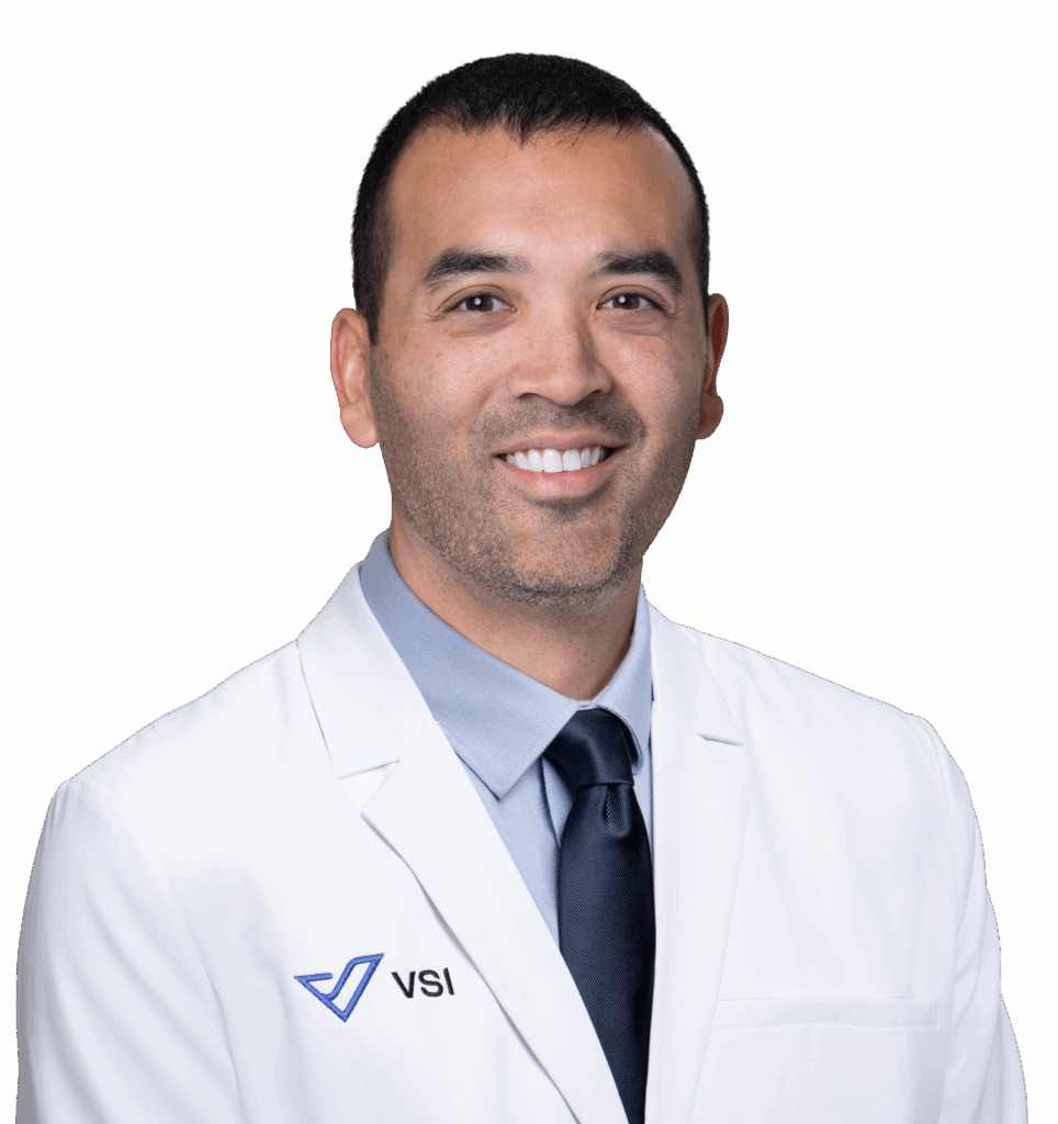 Head shot of man in white doctors coat with VSI written on it plus logo