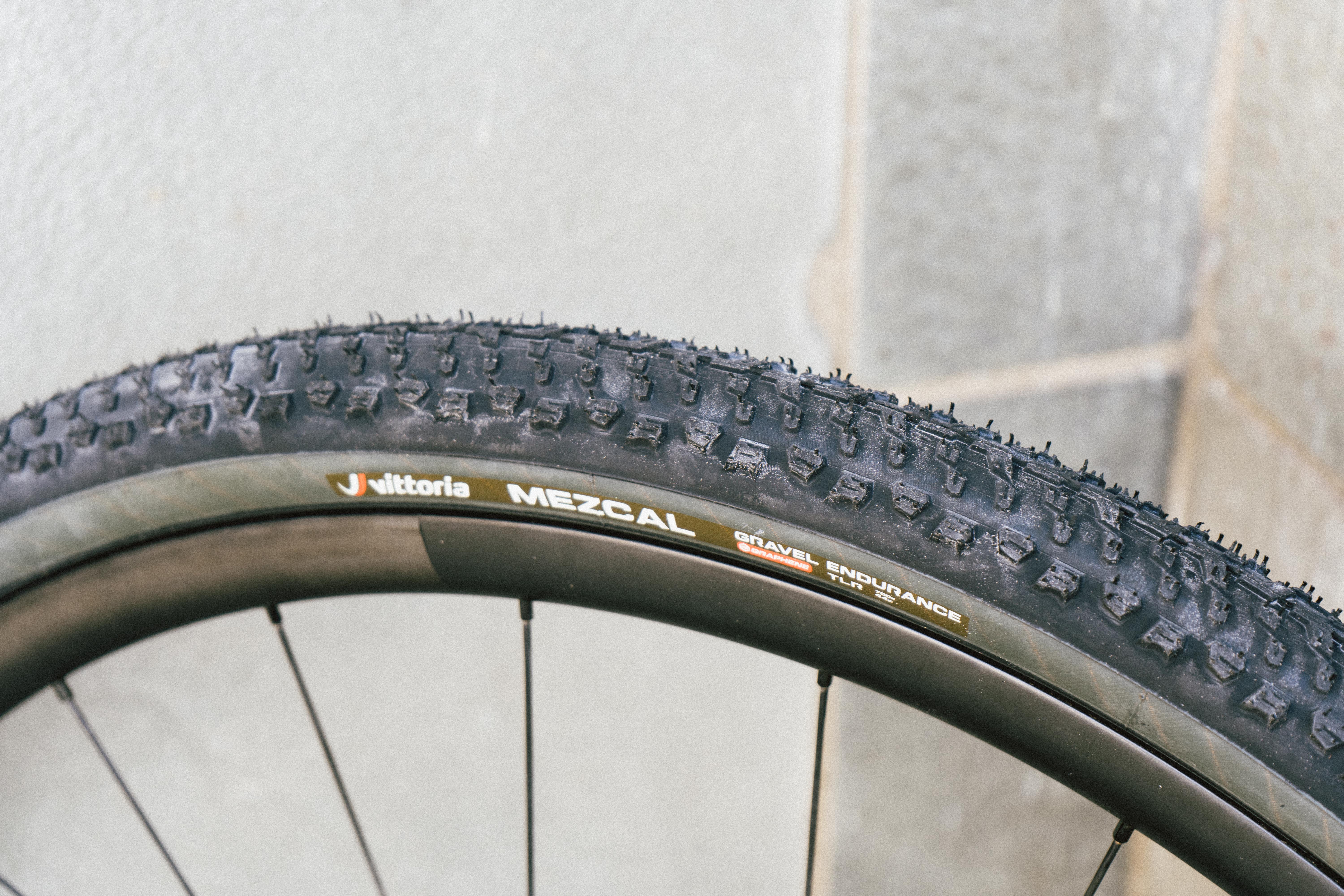 A black gravel tyre against a stone wall